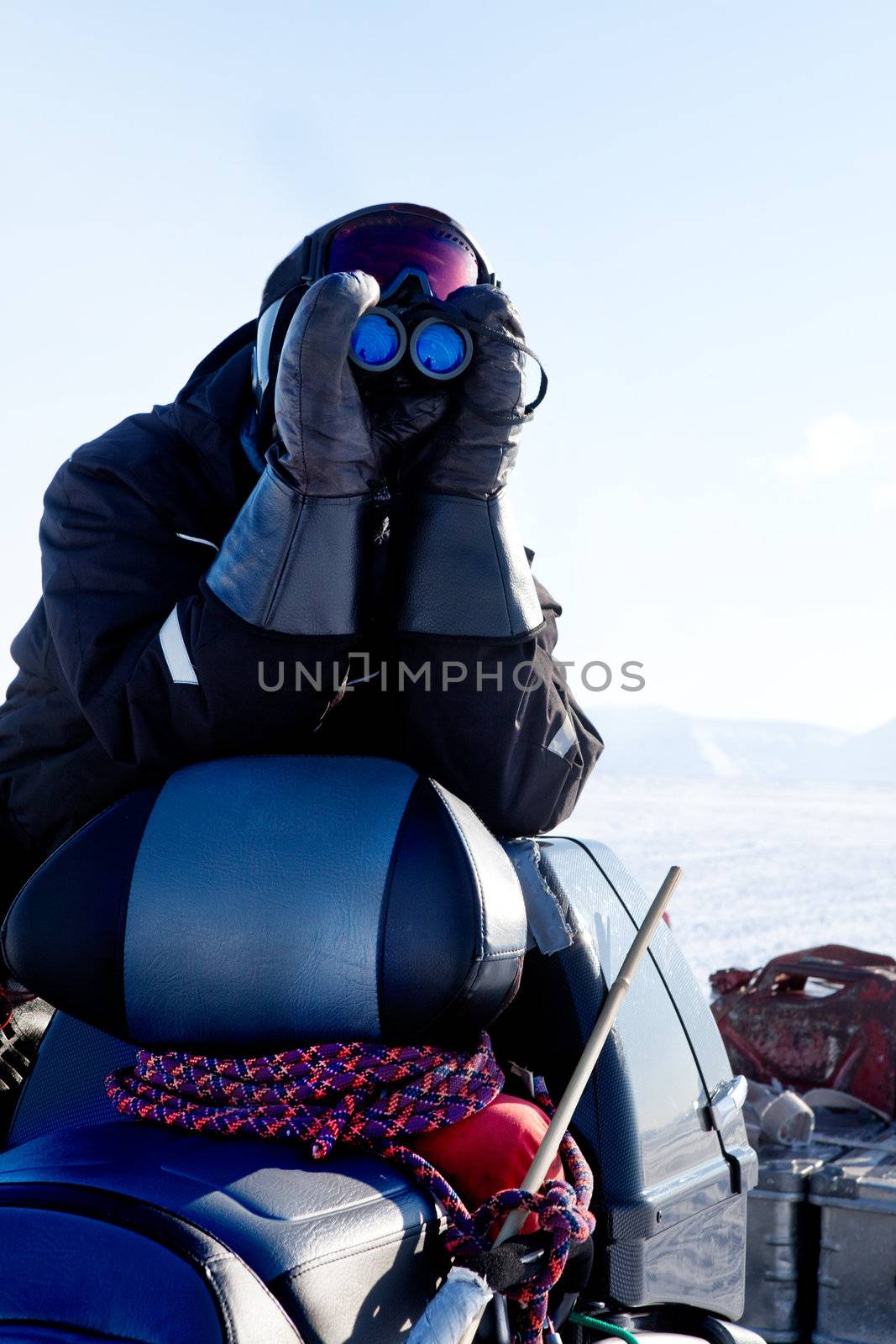 A winter adventure guide scouting the landscape for danger