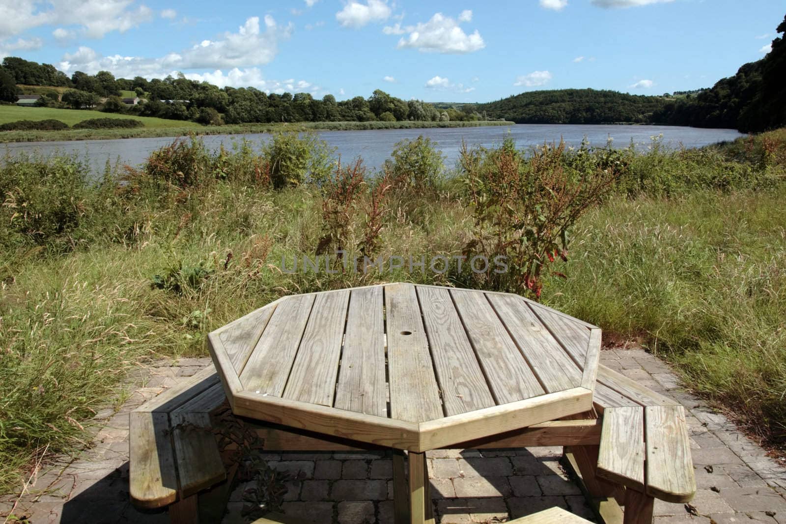 a picnic bench in knockanore county waterford in the south of ireland in summer on the blackwater river edge