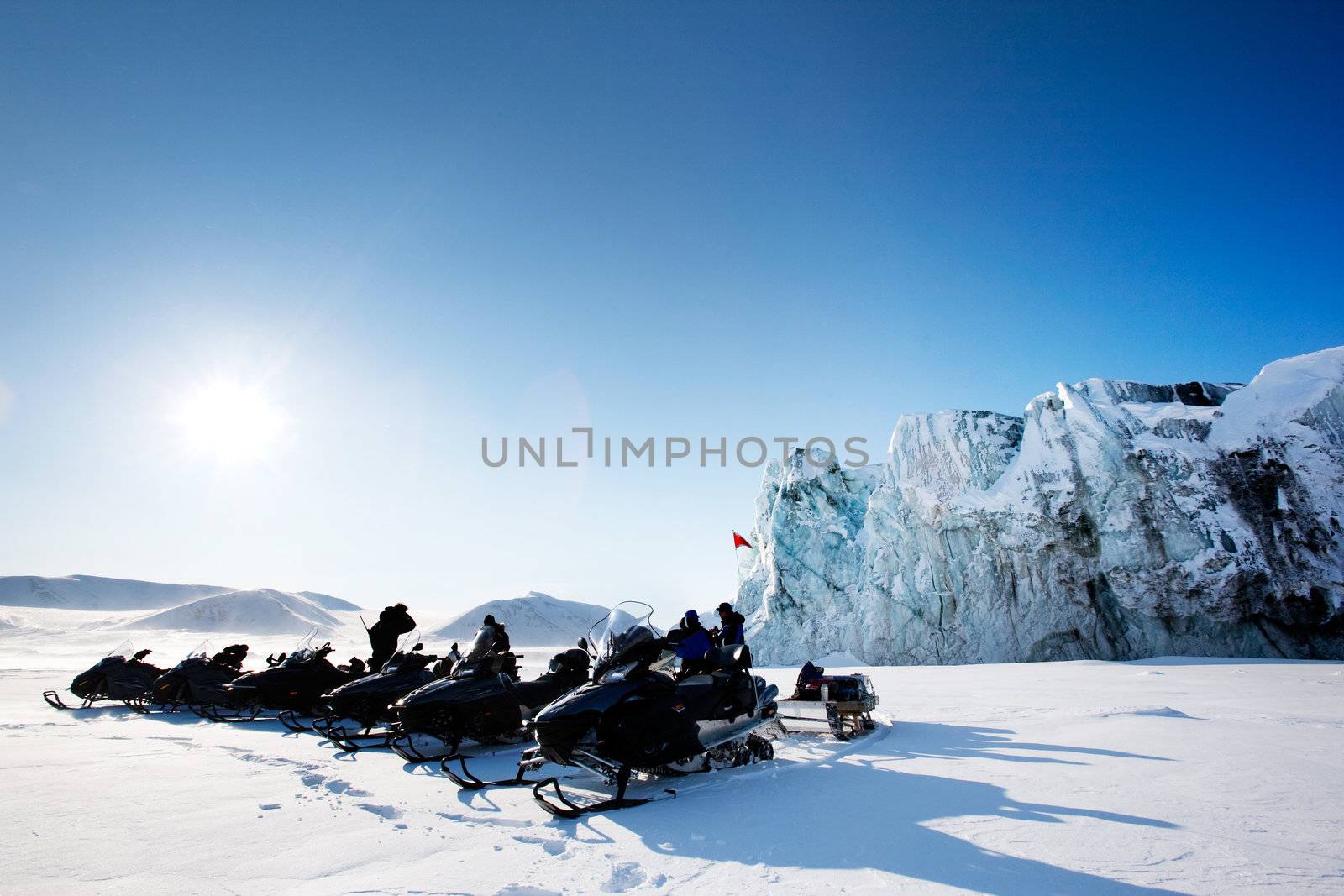 A number of snowmobiles near a glacier in Svalbard, Norway