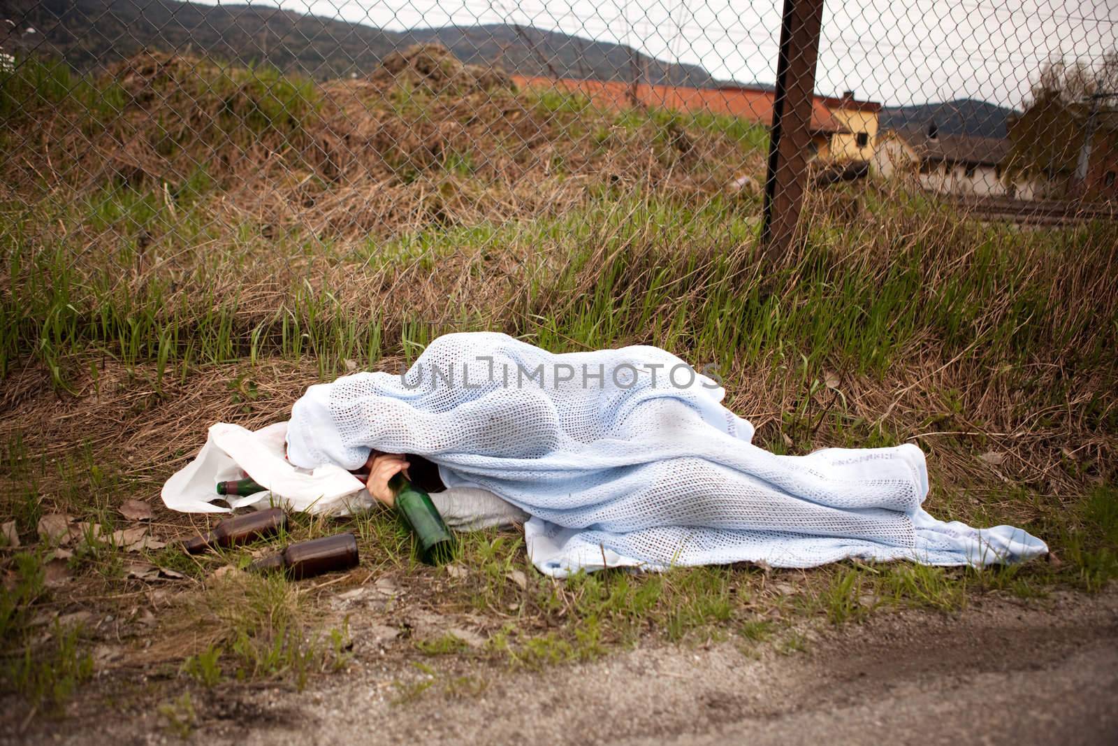 A homeless drunk person sleeping in the ditch