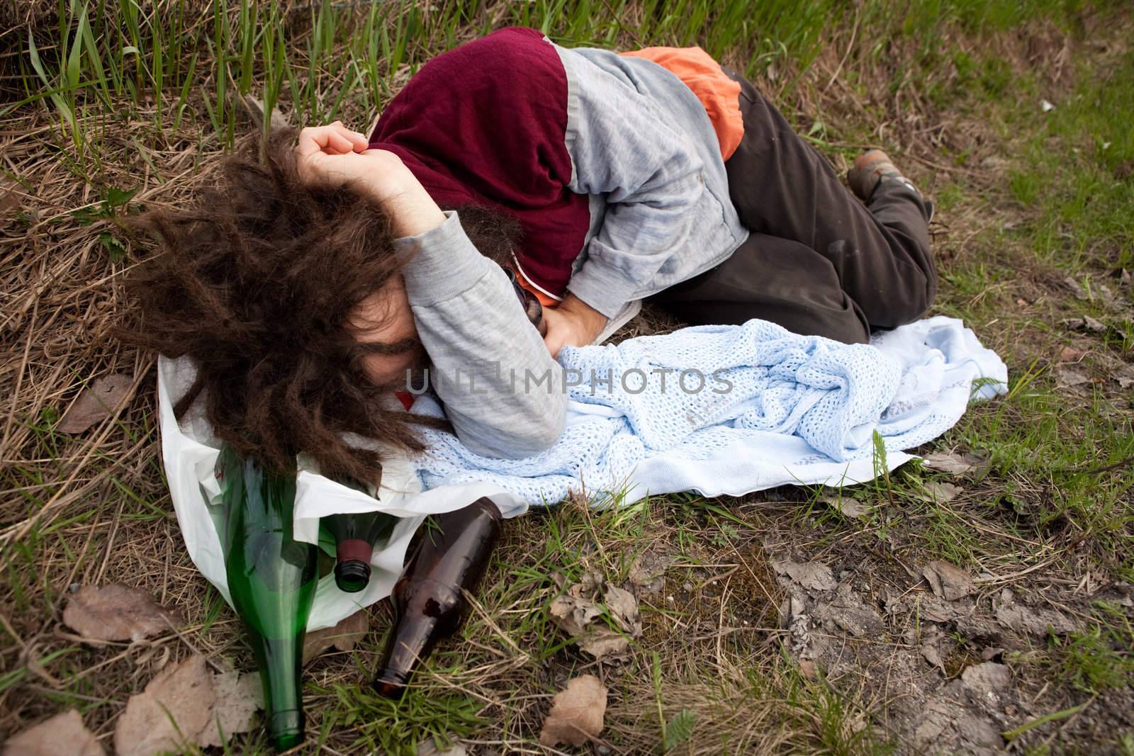 A drunk passed out in the ditch with a bunch of alcohol bottles