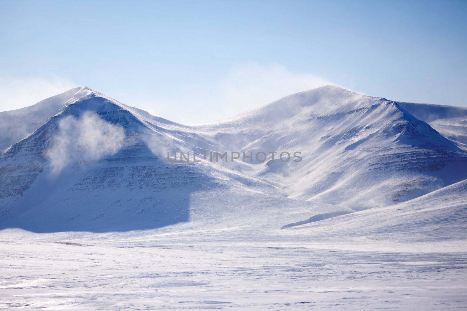 A mountain with blowing snow in a winter landscape