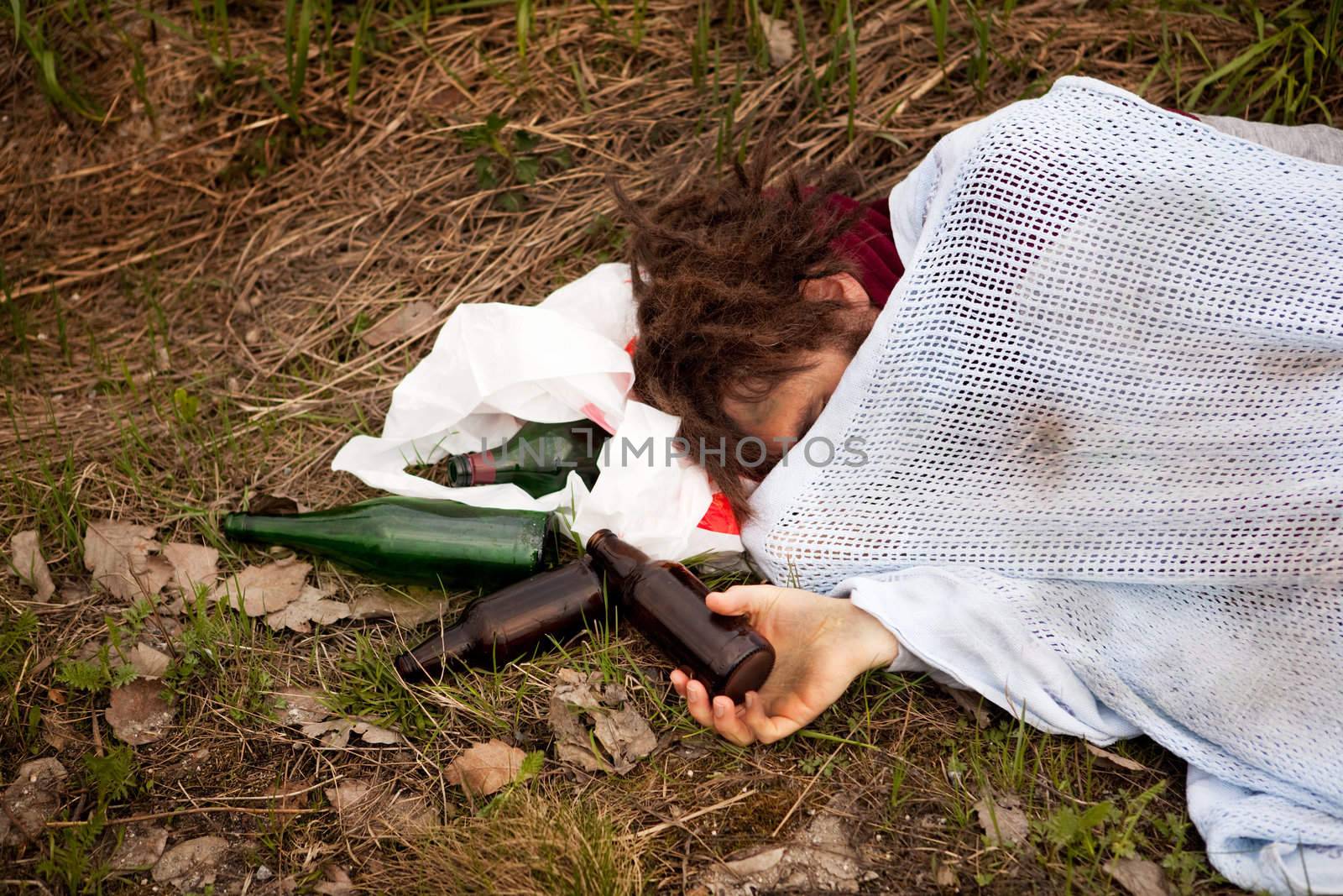 A drunk homeless man sleeping in a ditch