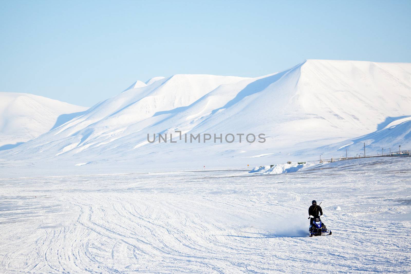 An arctic landscape with a snowmobile in the foreground