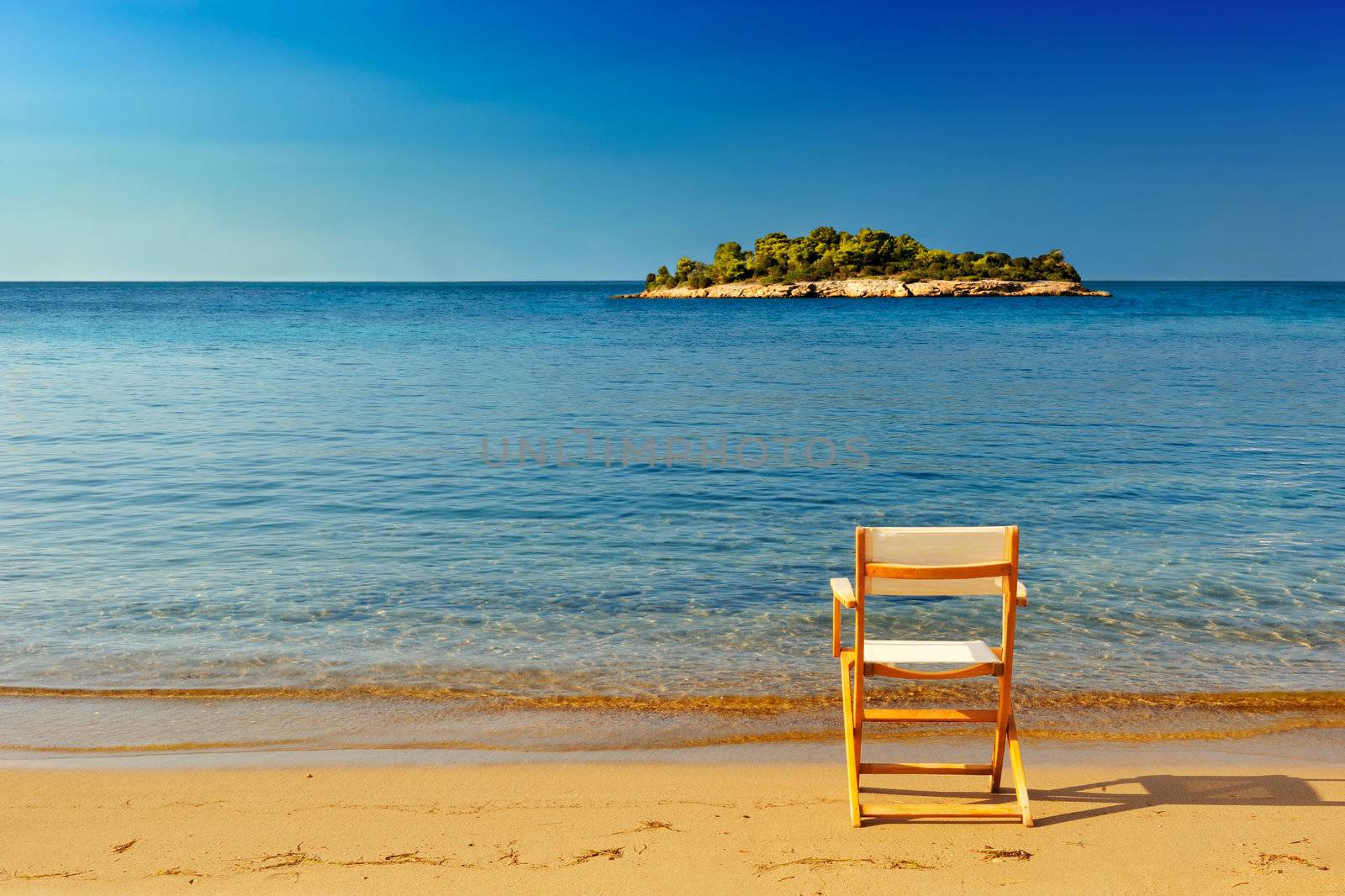A chair on a sandy beach offering a place to enjoy the view and serenity of the location