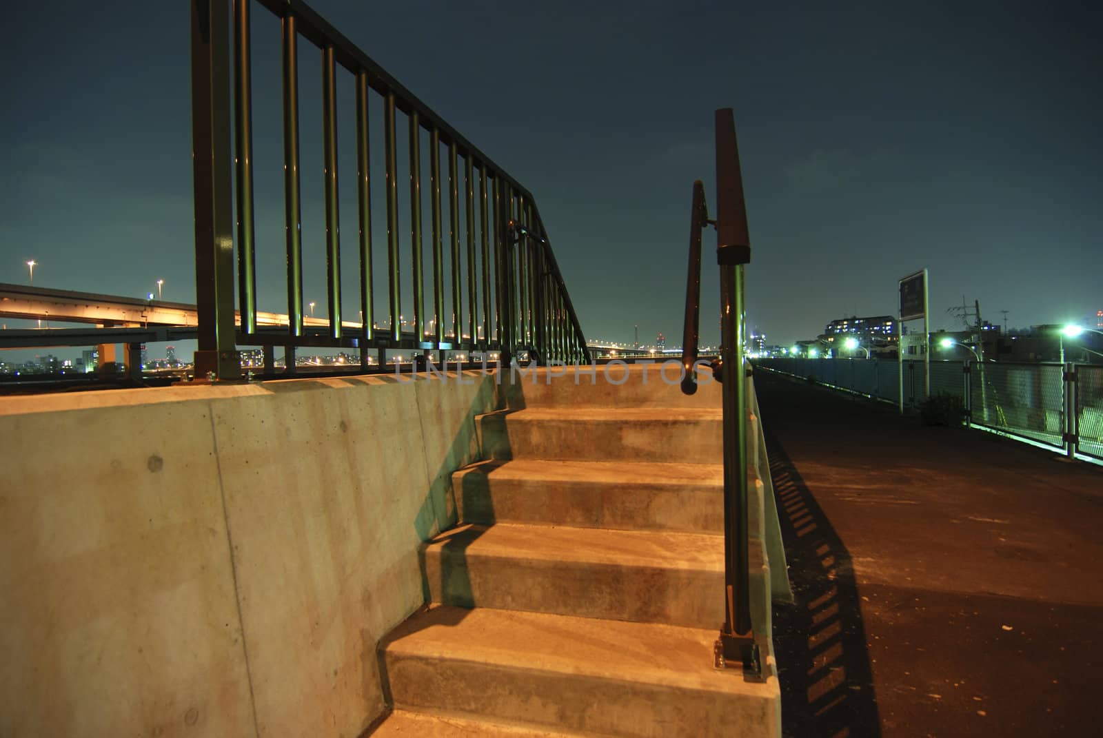 outdoor night stairs with metallic handrails over dark blue sky background