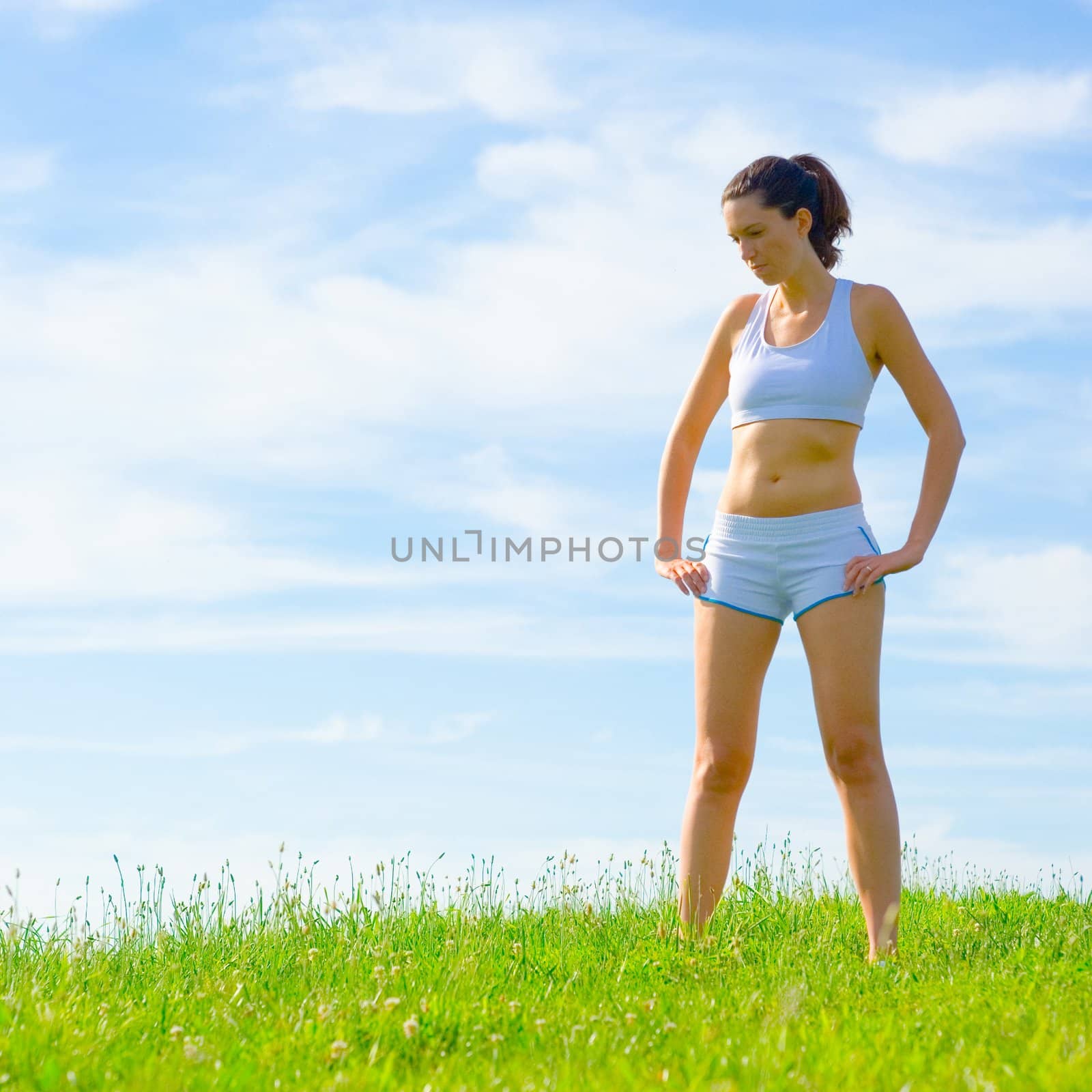 Mature woman athlete practicing in a spring meadow, from a complete series.