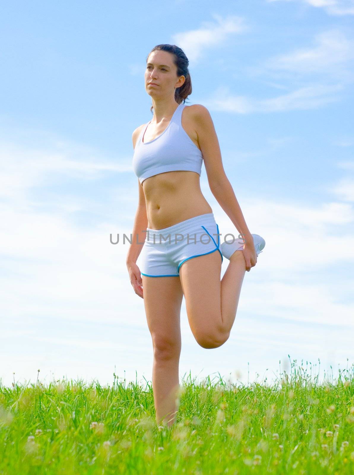 Mature woman athlete practicing in a spring meadow, from a complete series.
