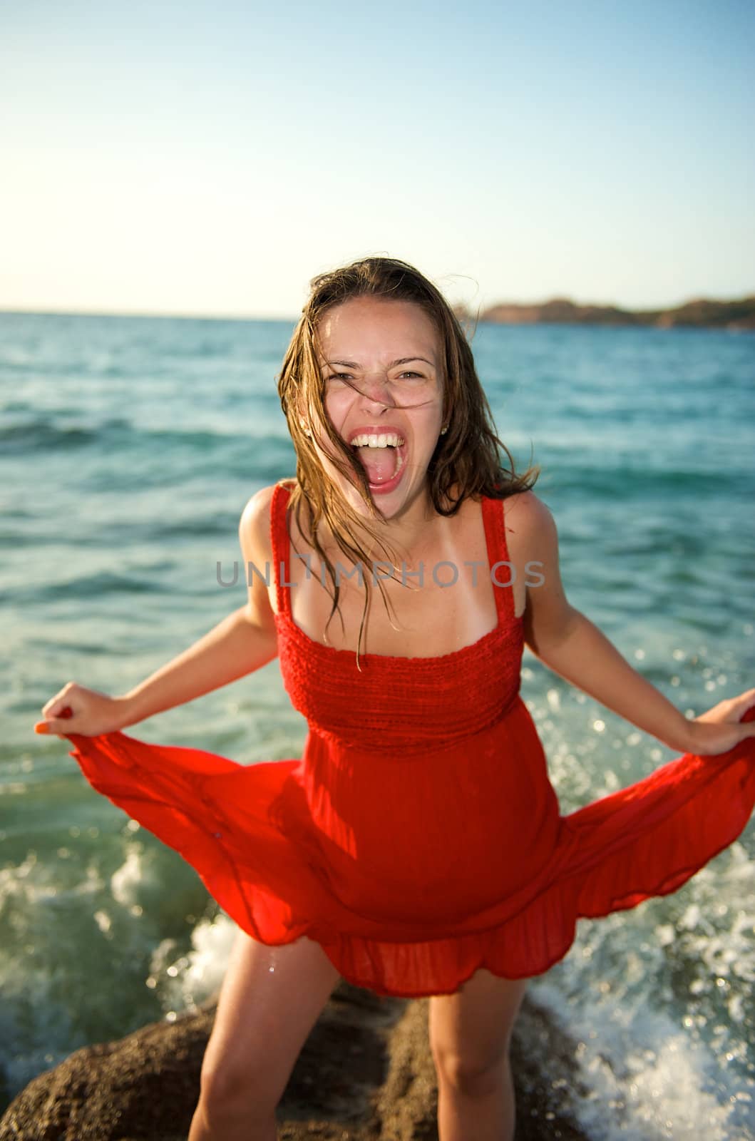 Pretty girl screaming on the beach during her vacation