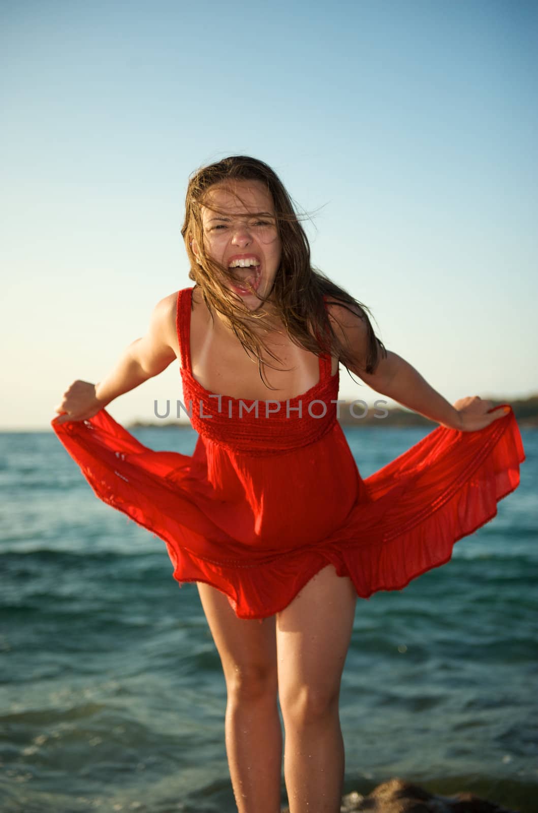 Pretty girl screaming on the beach during her vacation