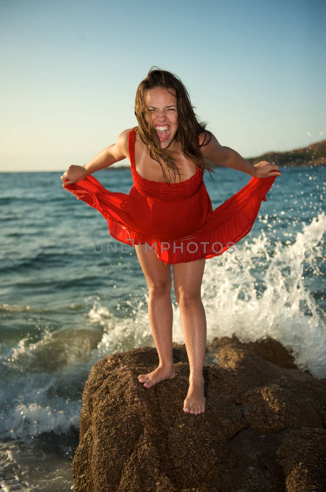 Pretty girl screaming on the beach during her vacation