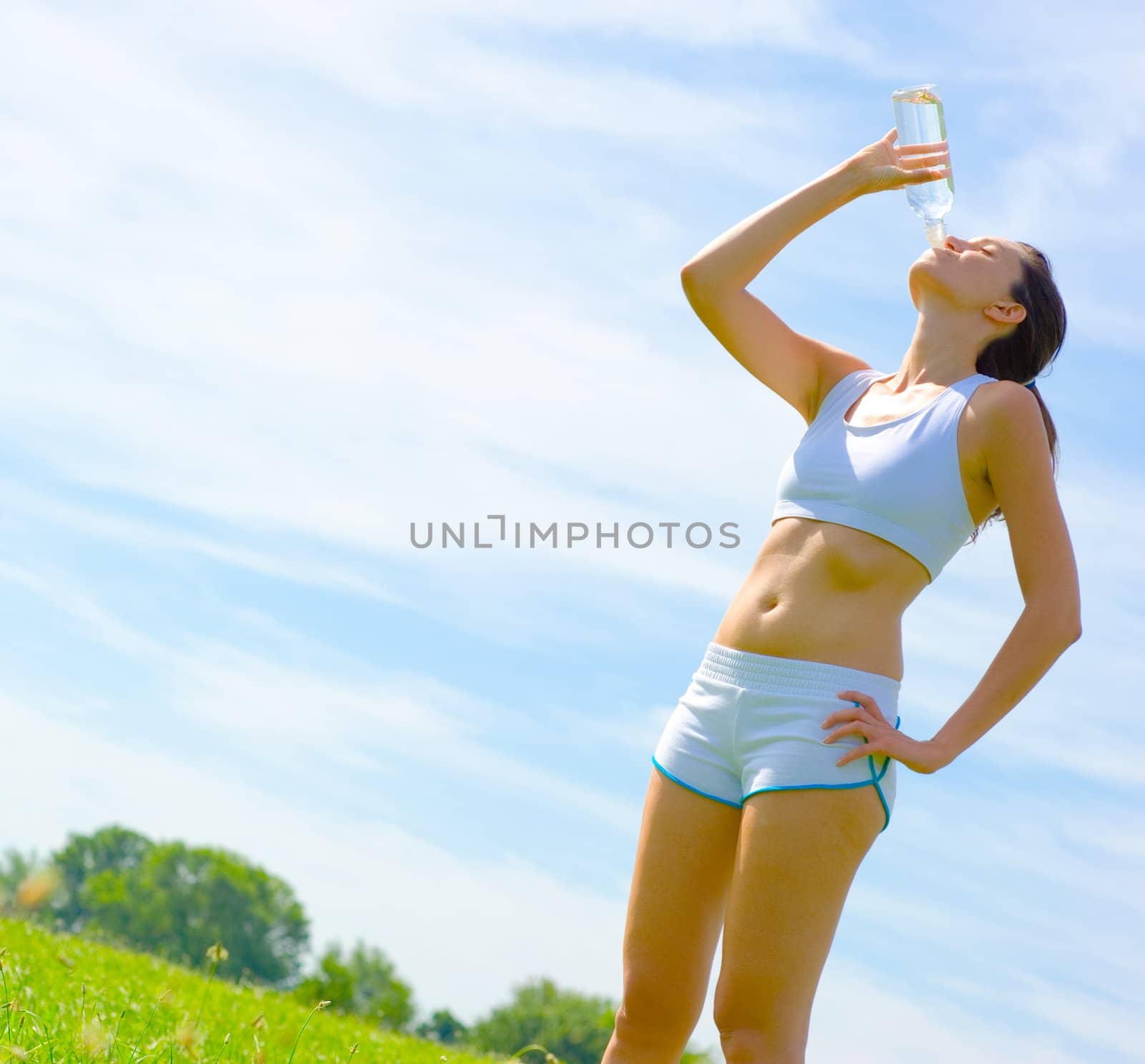 Mature woman athlete practicing in a spring meadow, from a complete series.