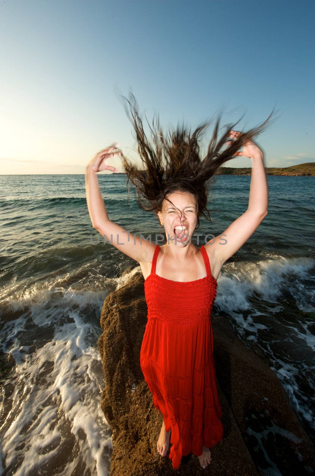 Pretty girl moving her hair on the beach at sunset time