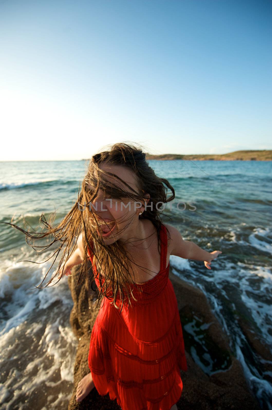 Pretty girl moving her hair on the beach at sunset time