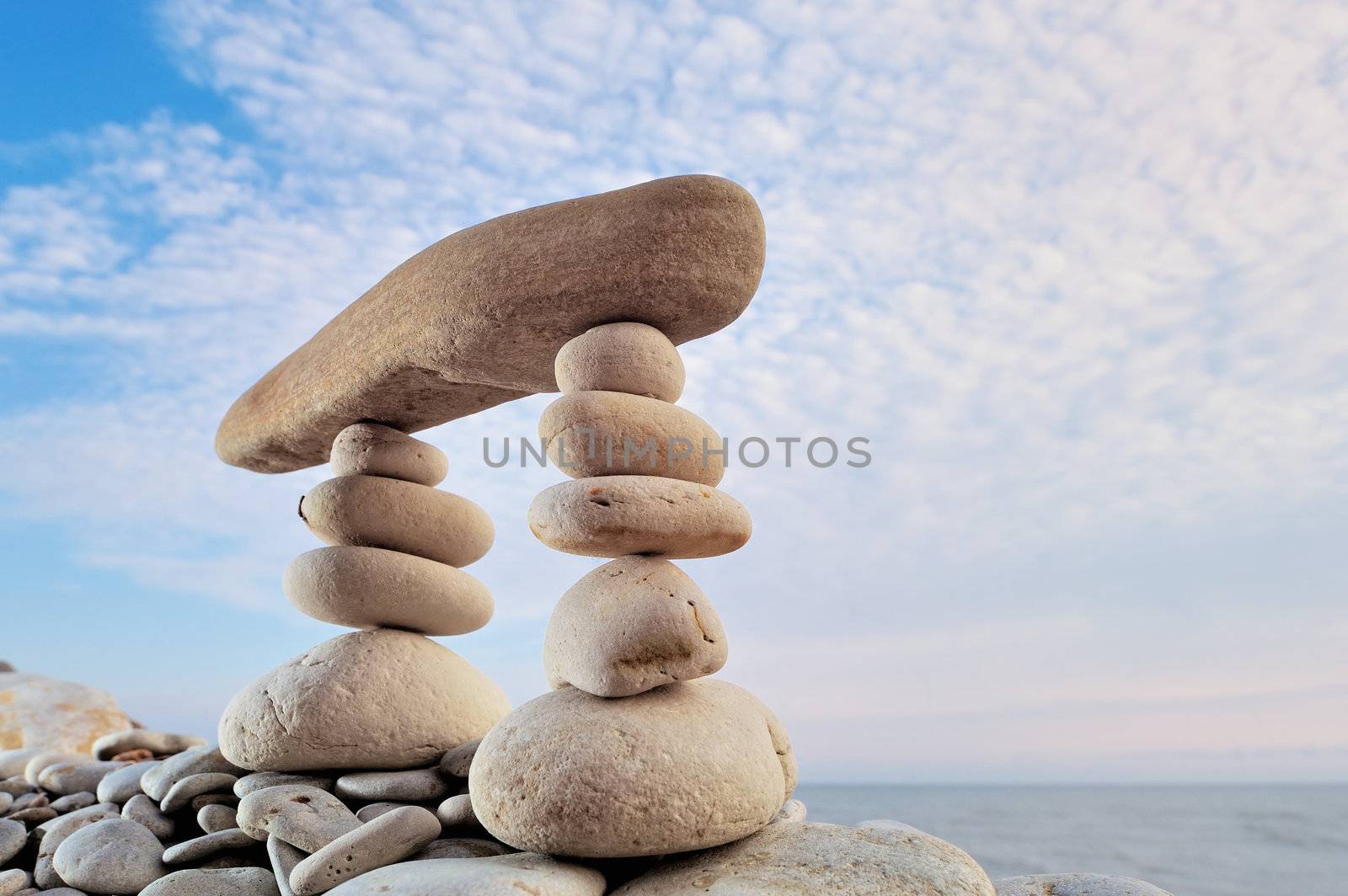 Long horizontal stone is between a stack of pebbles