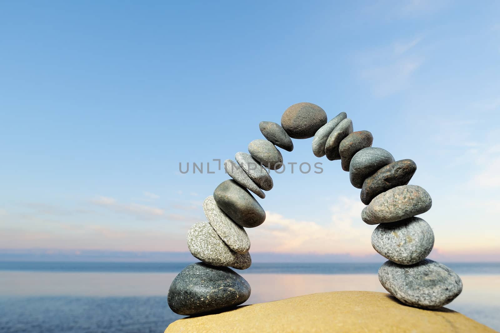 Grey pebbles are formed as curve on the seacoast