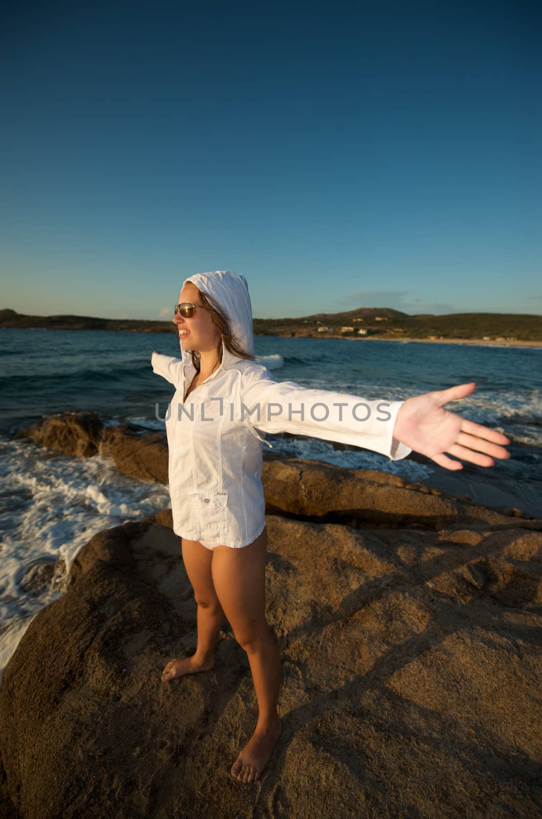 Wonderful pretty girl wearing a bikini posing on the beach at sunset time