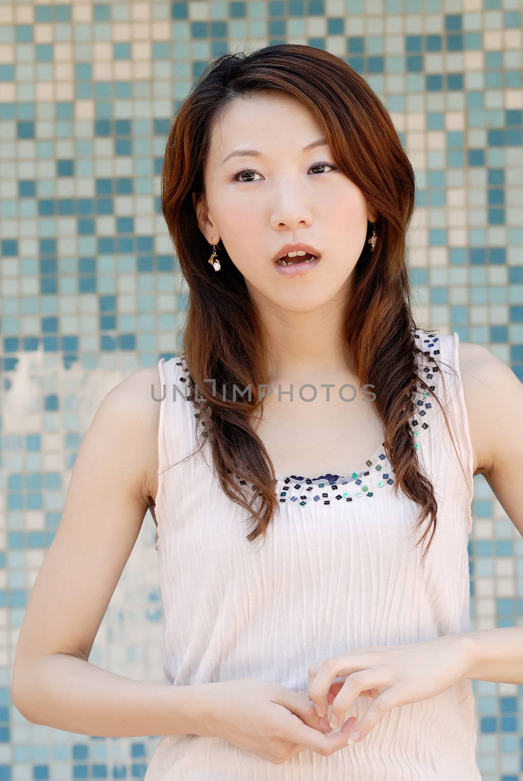 Here is a beautiful Asian lady in front of mosaic and think.