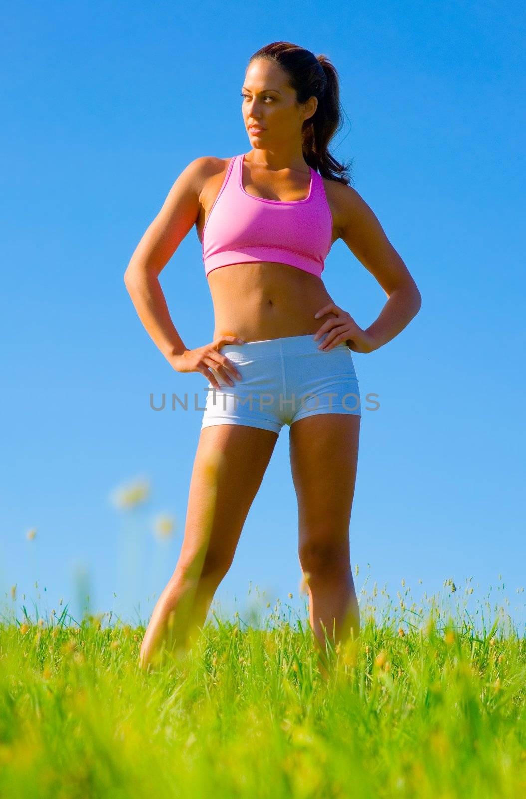 Athletic woman working out in a meadow, from a complete series of photos.