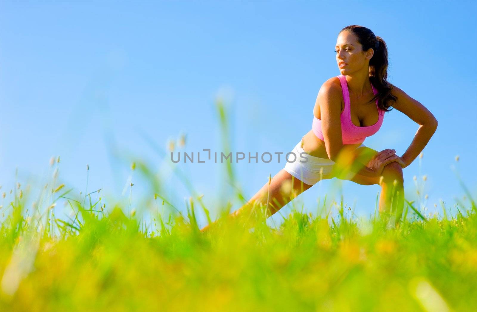 Athletic woman working out in a meadow, from a complete series of photos.