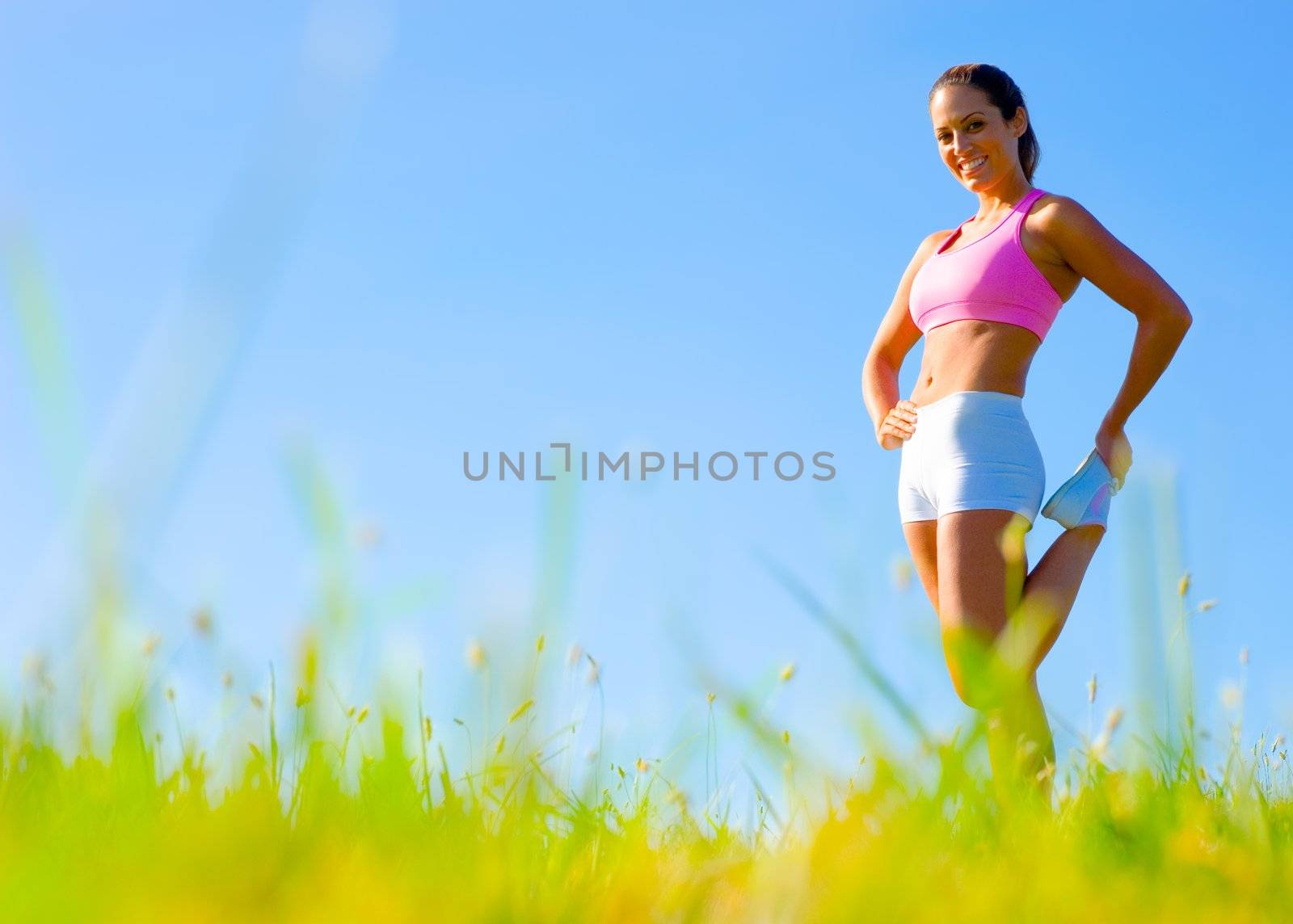 Athletic woman working out in a meadow, from a complete series of photos.