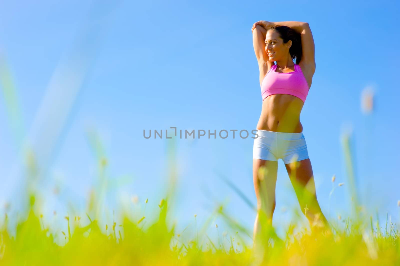 Athletic woman working out in a meadow, from a complete series of photos.