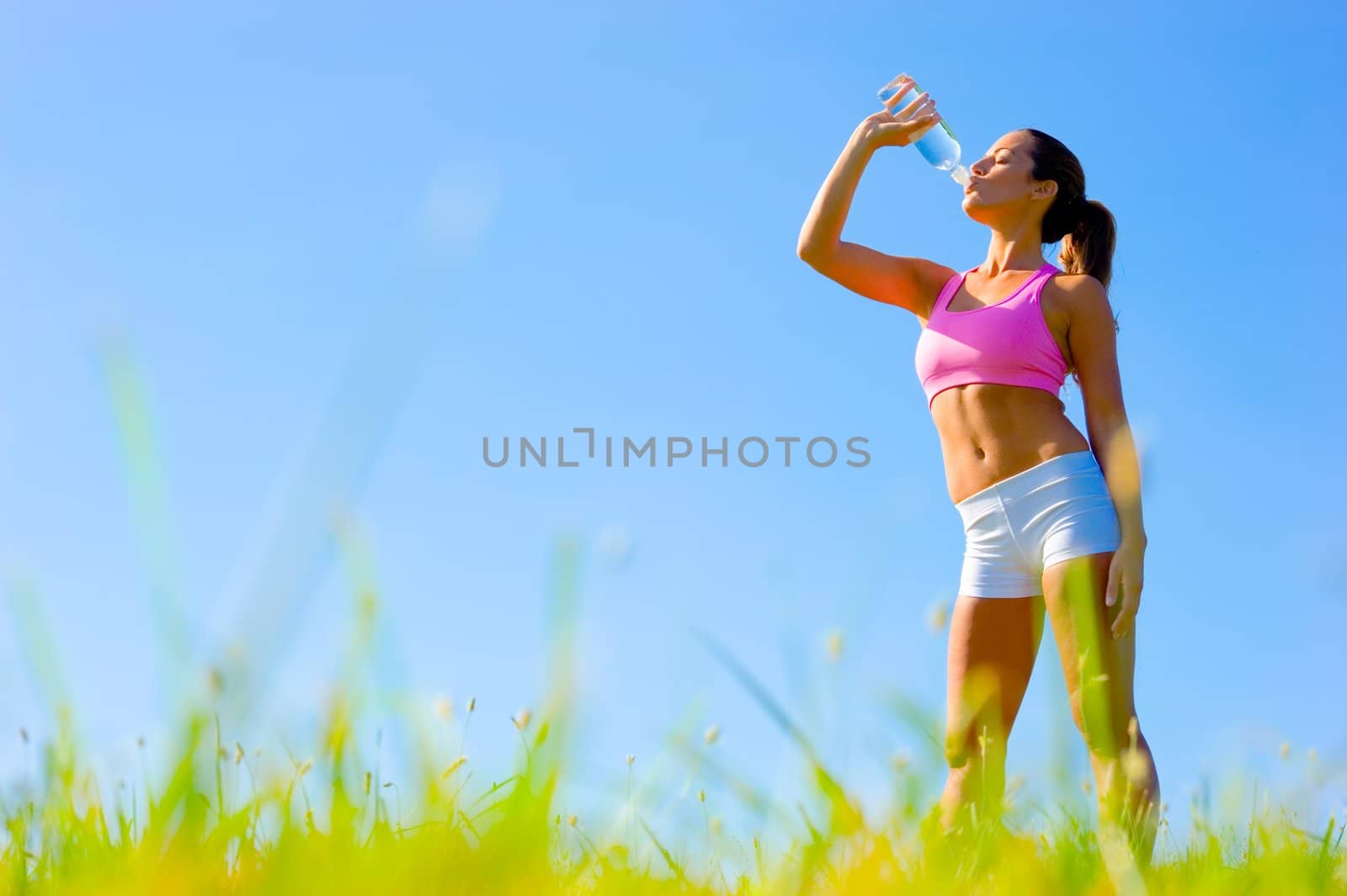 Athletic woman working out in a meadow, from a complete series of photos.