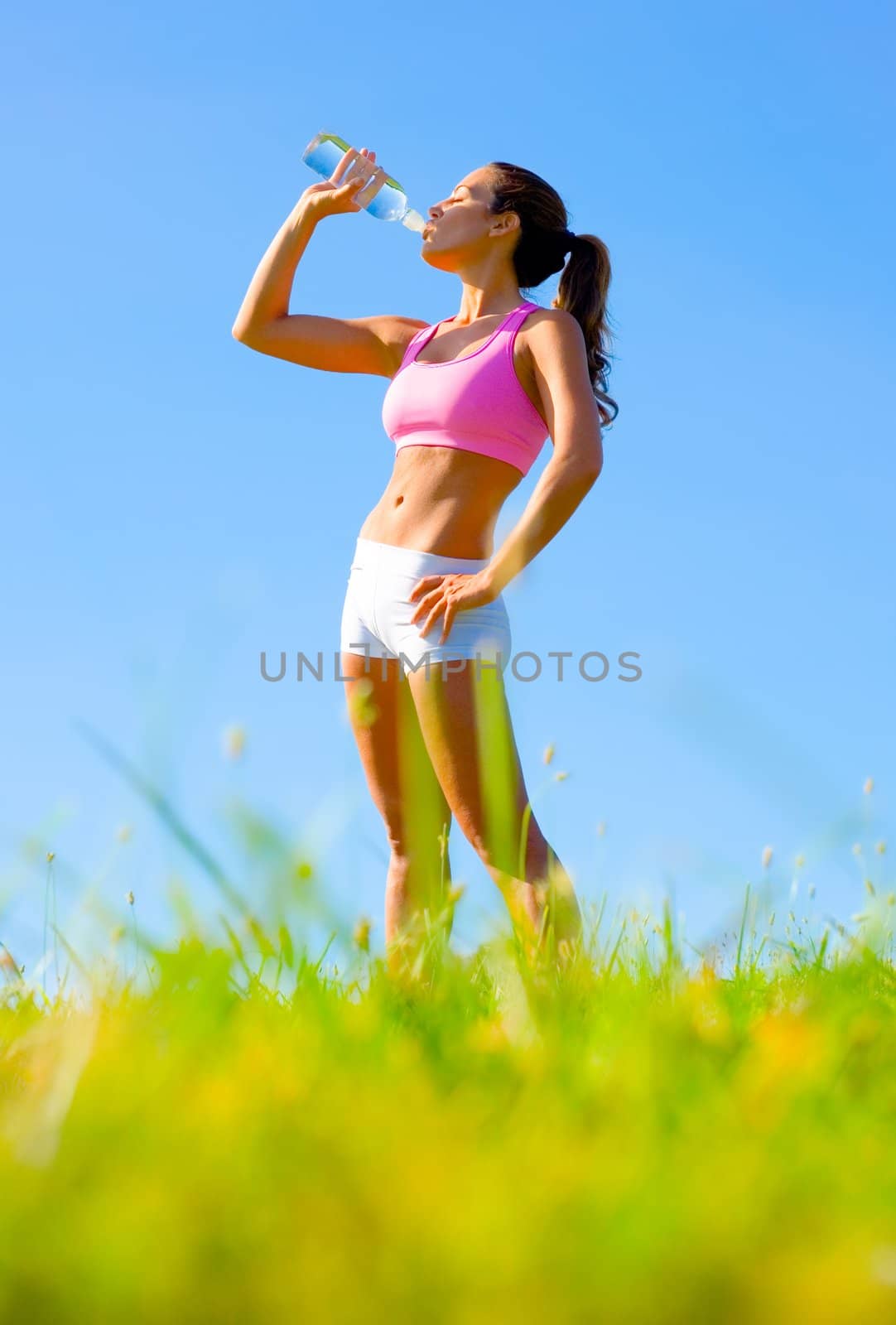 Athletic woman working out in a meadow, from a complete series of photos.