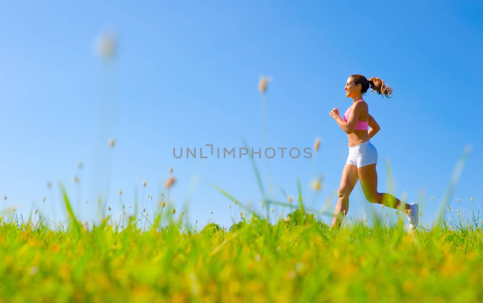 Athletic woman working out in a meadow, from a complete series of photos.