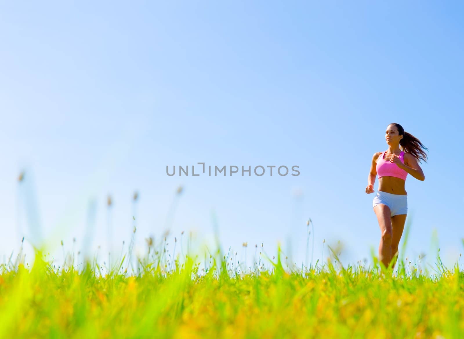 Athletic woman working out in a meadow, from a complete series of photos.