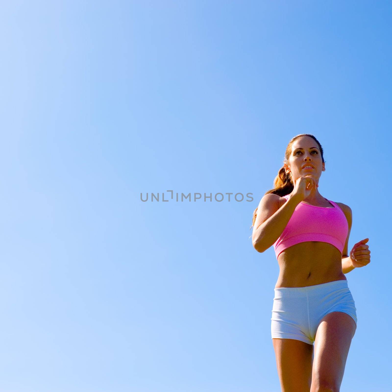 Athletic woman working out in a meadow, from a complete series of photos.