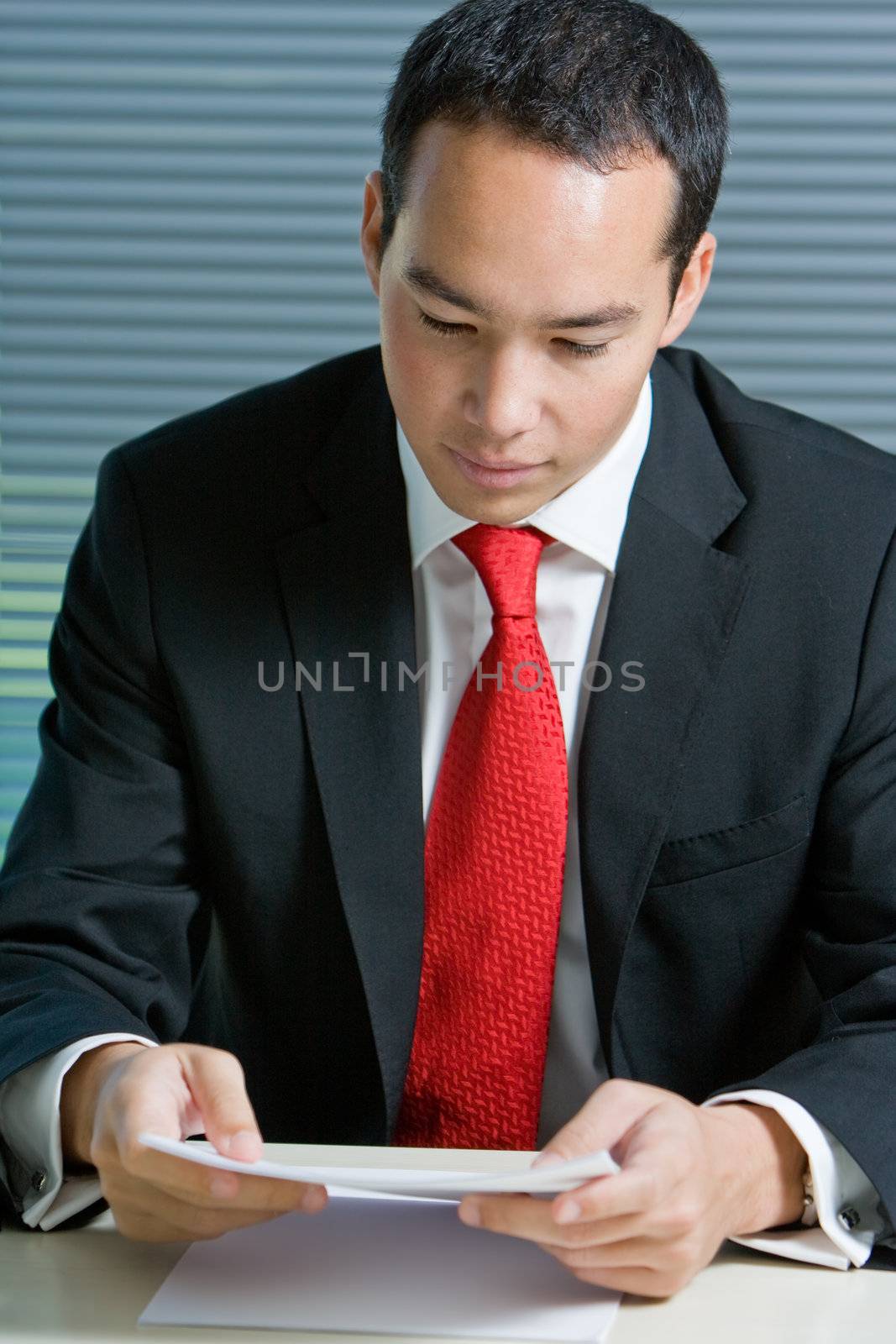 Smart eurasian business man in formal attire working and browsing with documents