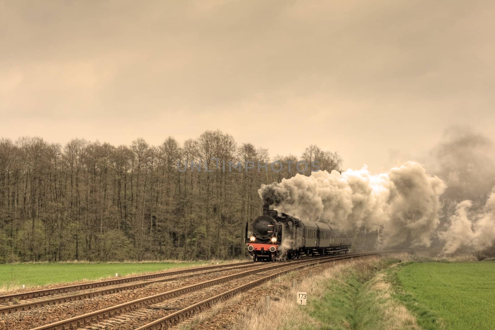 Old retro steam train passing through countryside
