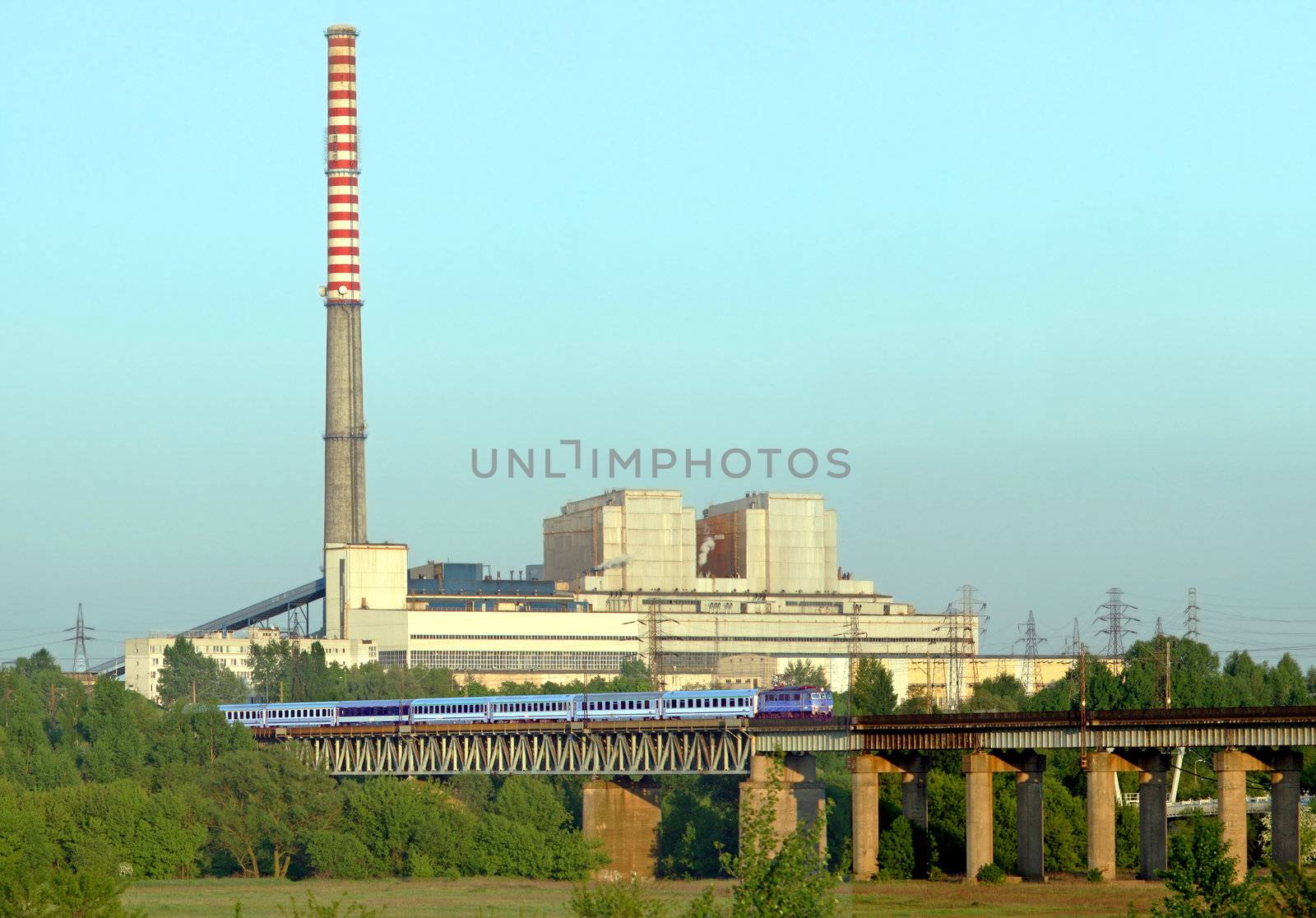 Industrial landscape with a intercity train and power plant
