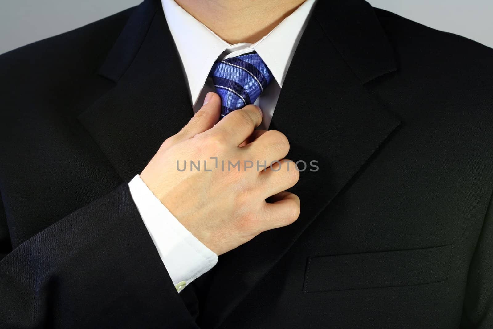 Businessman tying up his tie