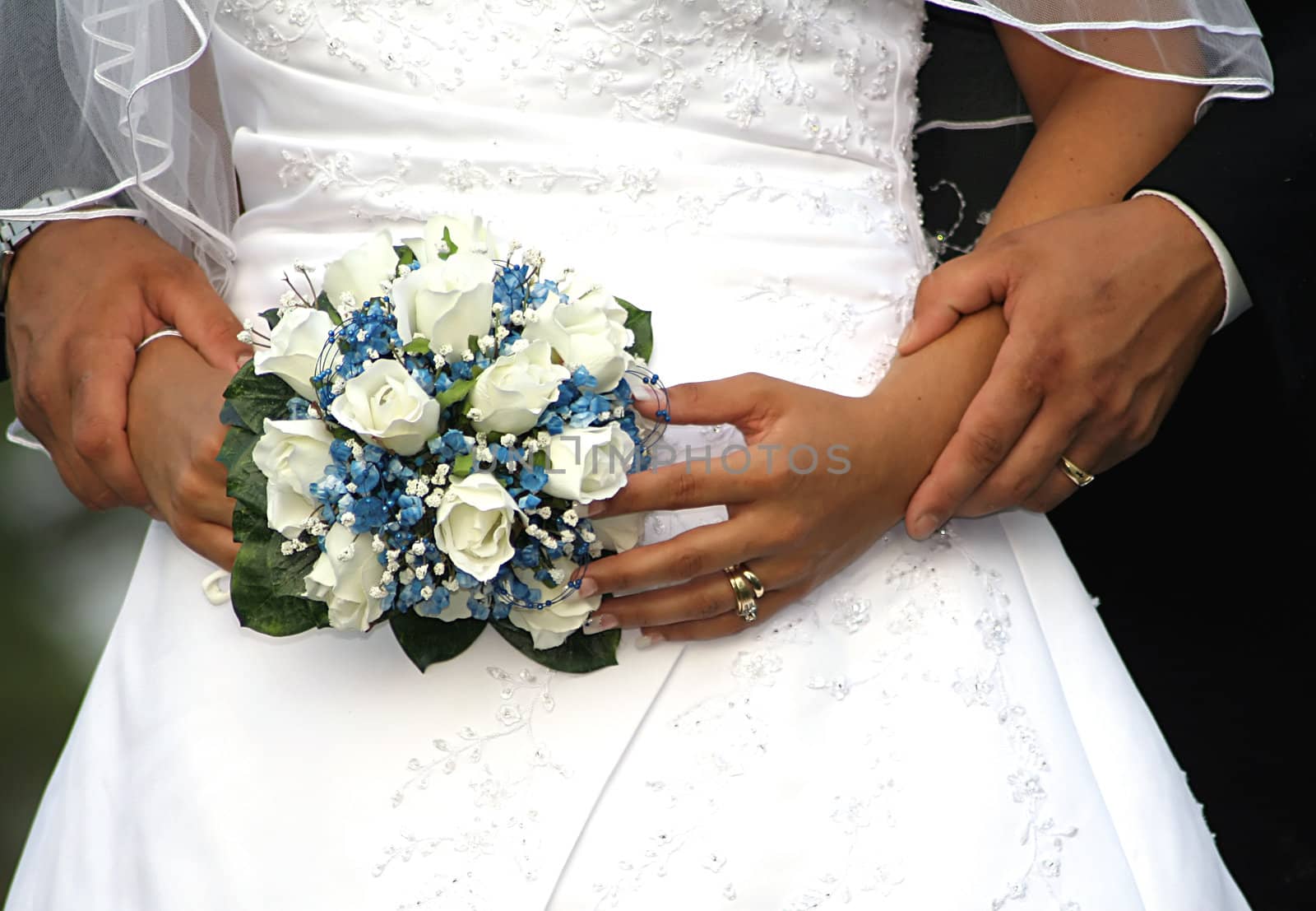 Bride and Grooms hands and bouquet on their wedding day

