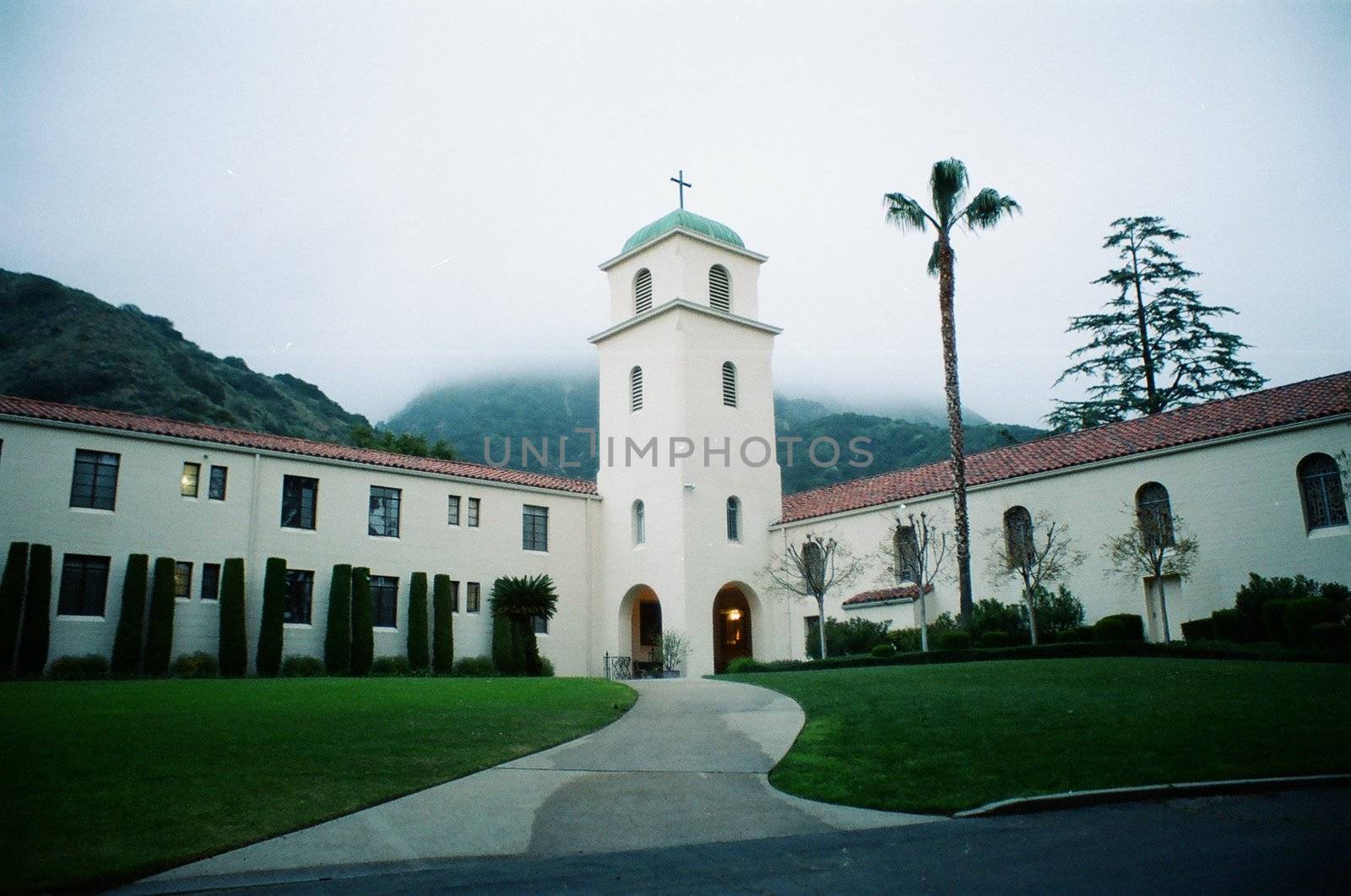 An abbey near the mountains, surrounded by fog