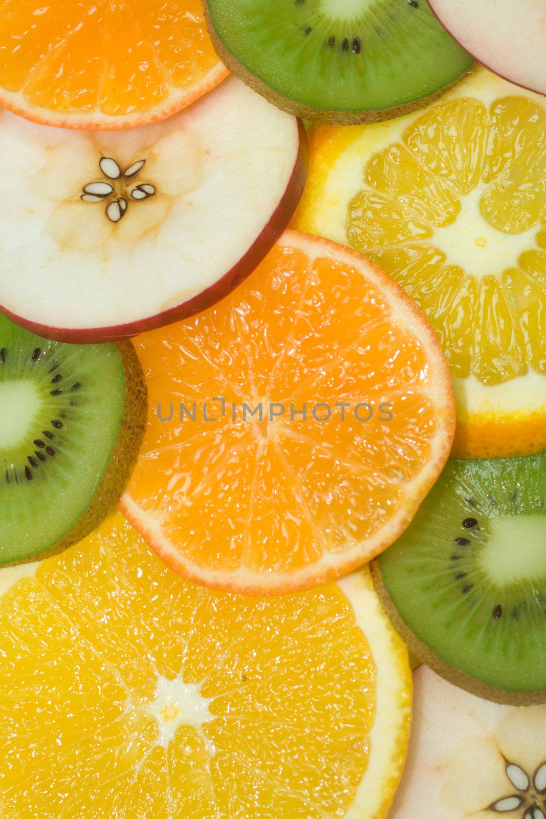 fruits background from slices kiwi, apple, tangerine and orange