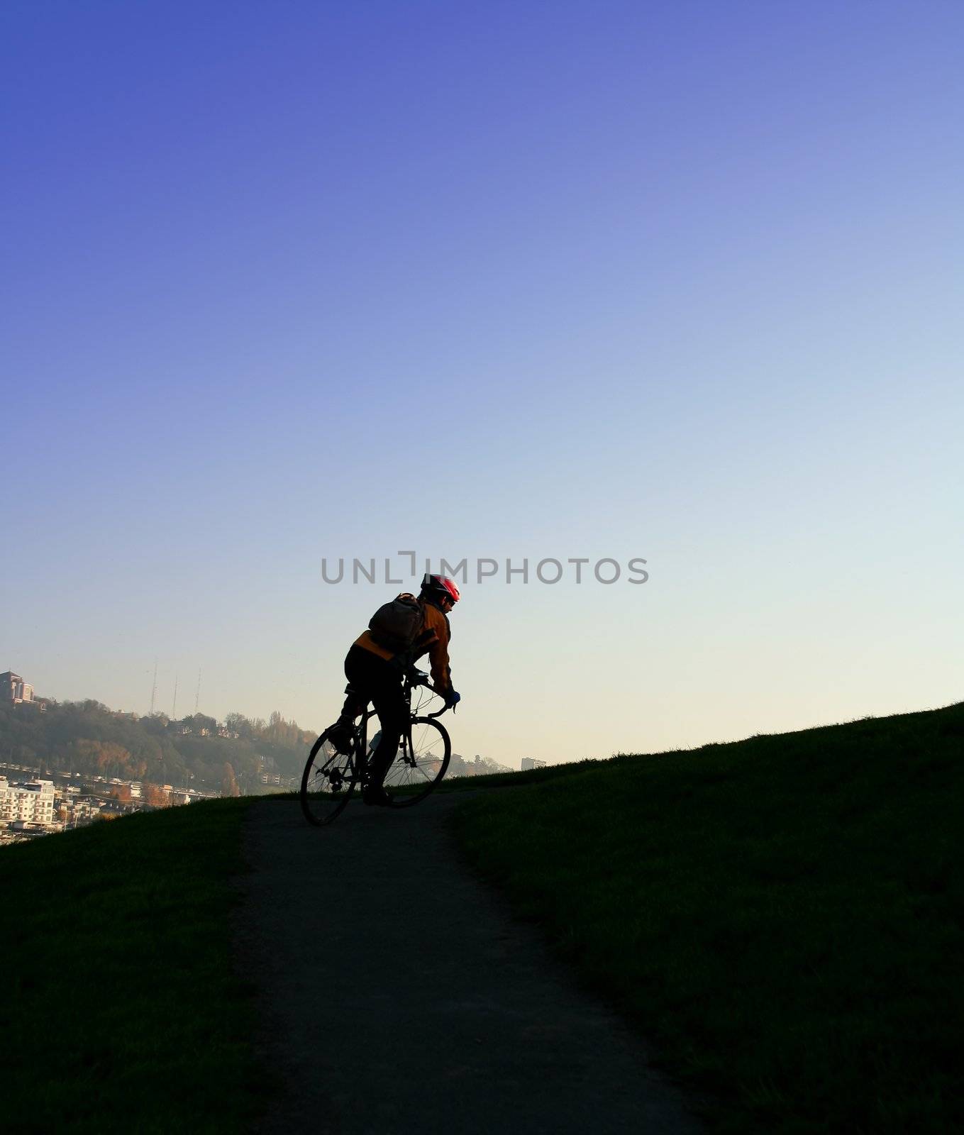 A man climbing uphill on a bicycle showing effort and determination