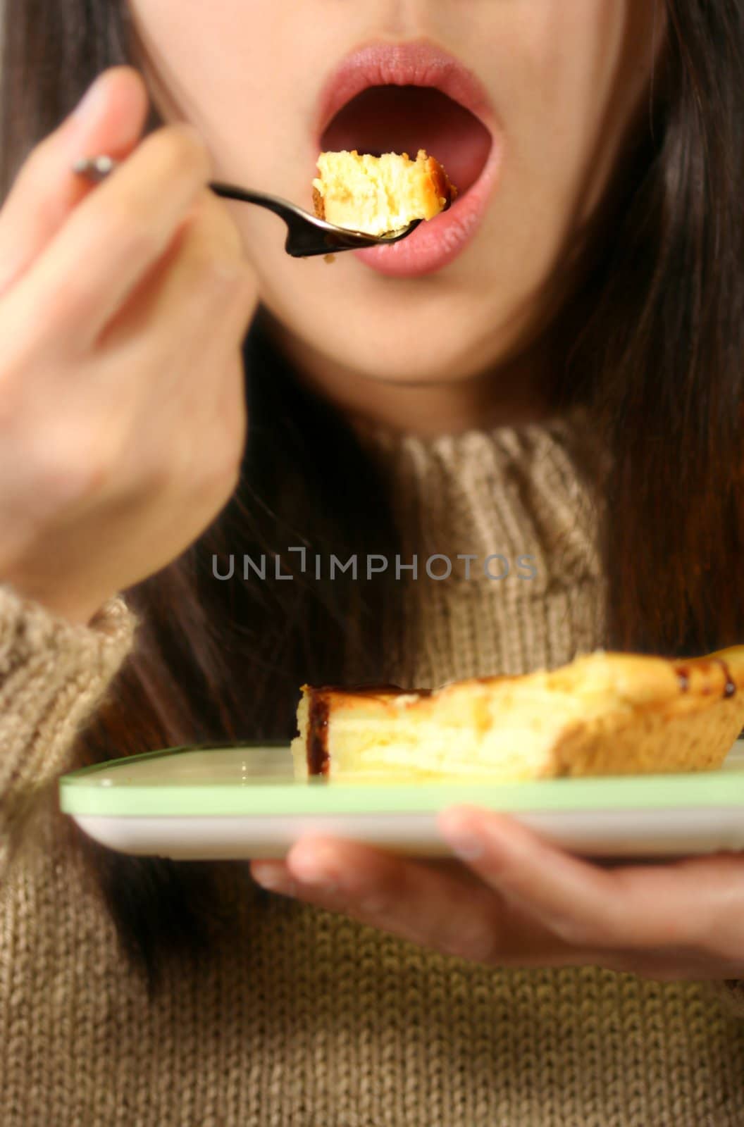 A woman eating a piece of cheese cake