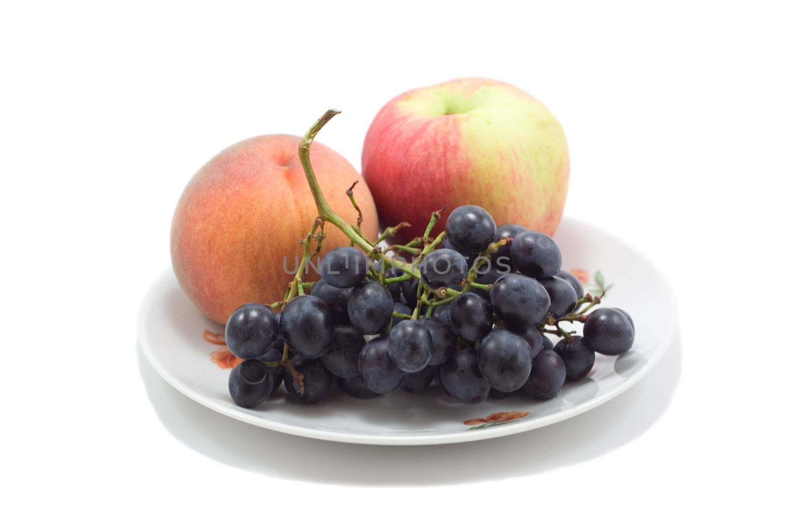 plate with fruits, peach, apple and grapes, isolated on white