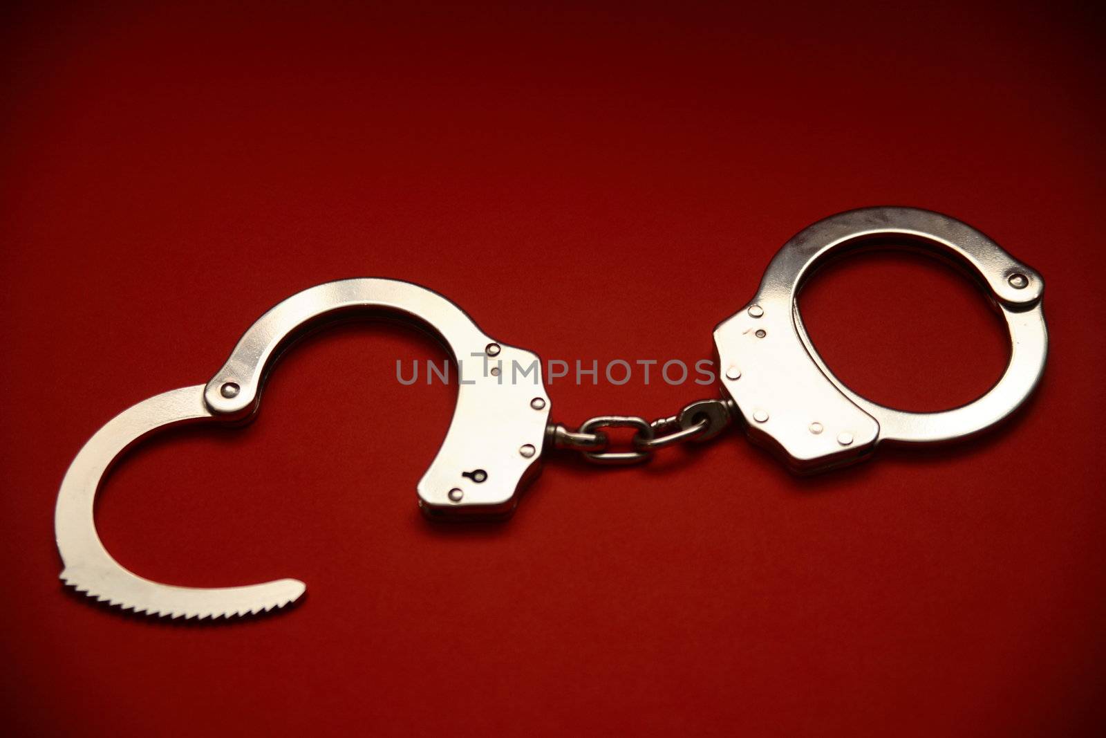 A pair of open handcuffs.