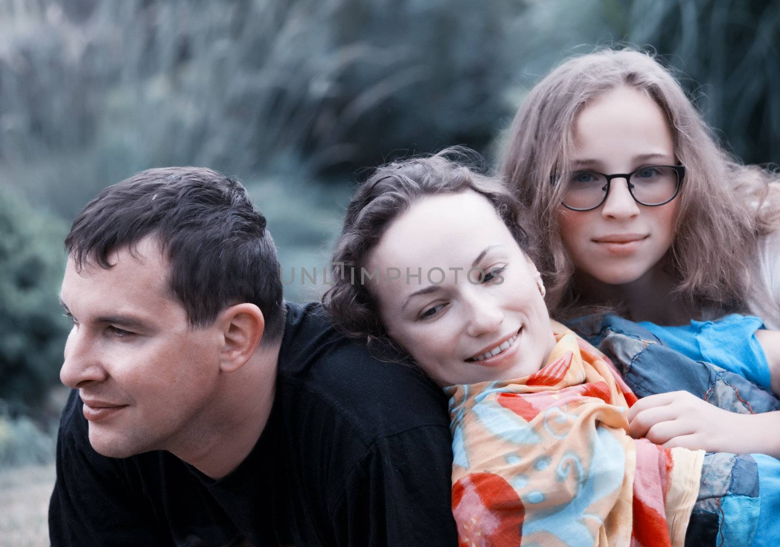 Portrait of parents with teenager daughter relaxing on nature