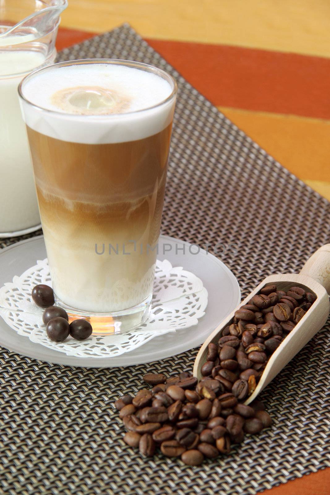 Latte Macchiato in glass with coffee grain on brown background
