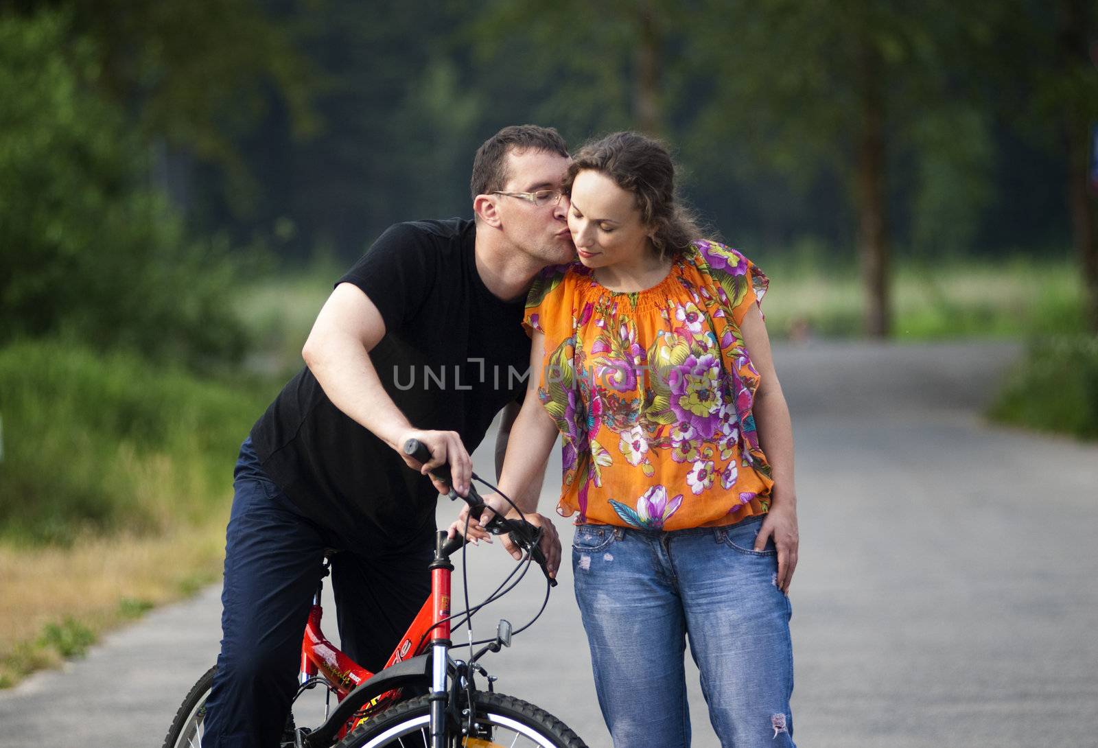 Happy couple in park with red bicycle