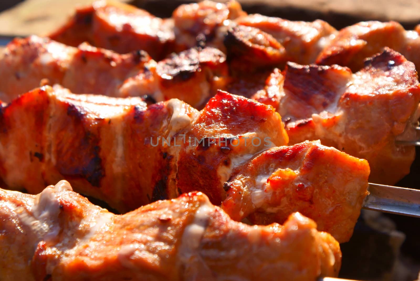 The meat, cooking on a grill in sunny day.