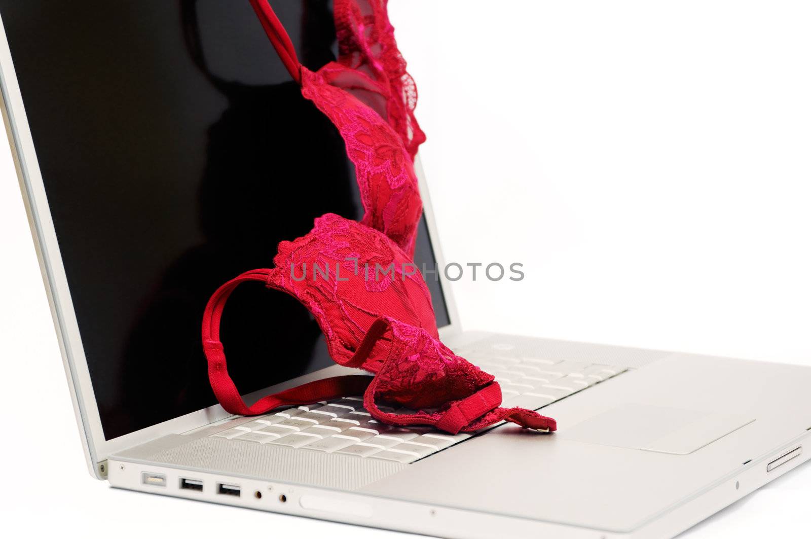 Red bra thrown on a modern laptop, against a white background. Room for text