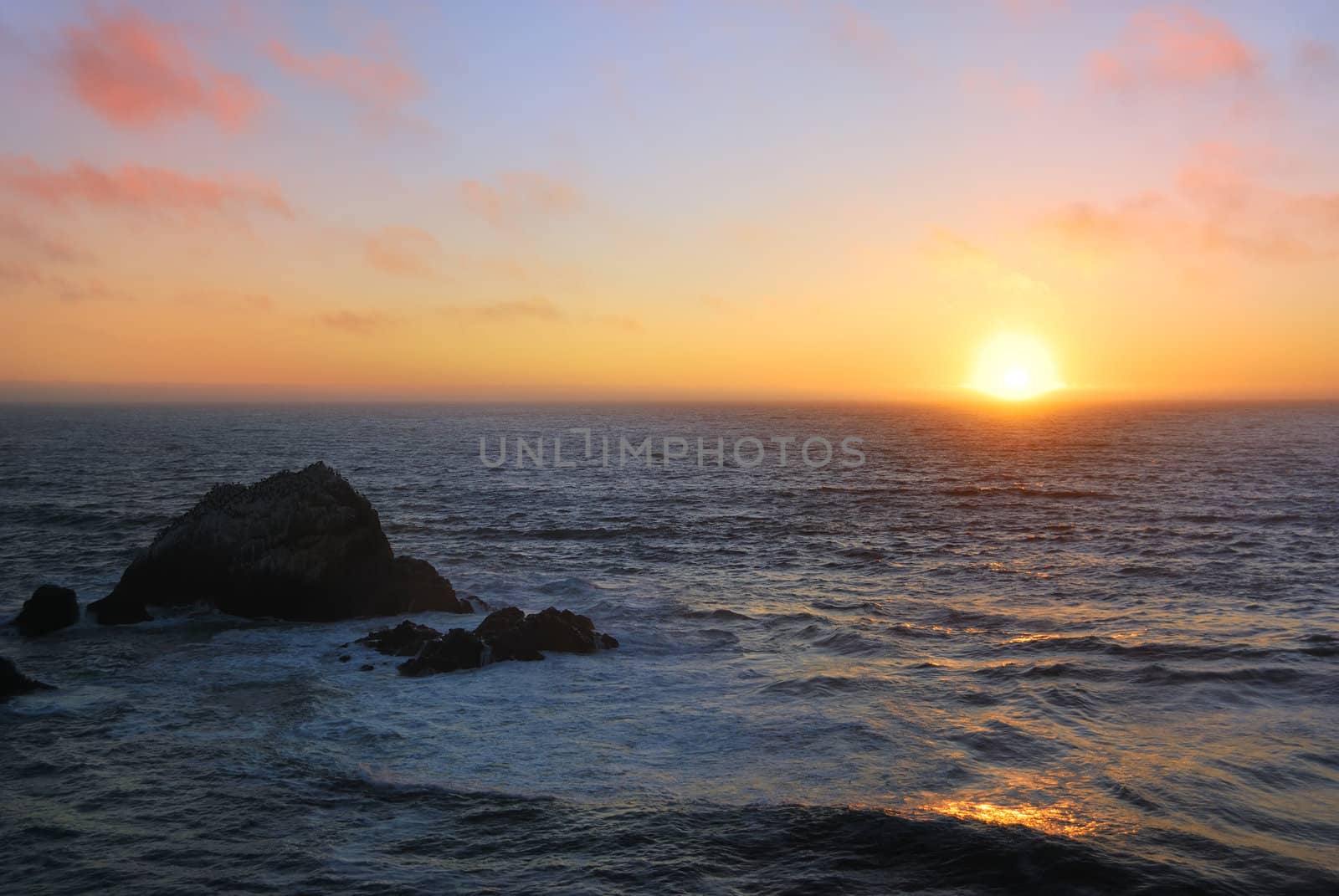 Sunset above the wavy Pacific as seen from the Ocean Beach in San Francisco, California.