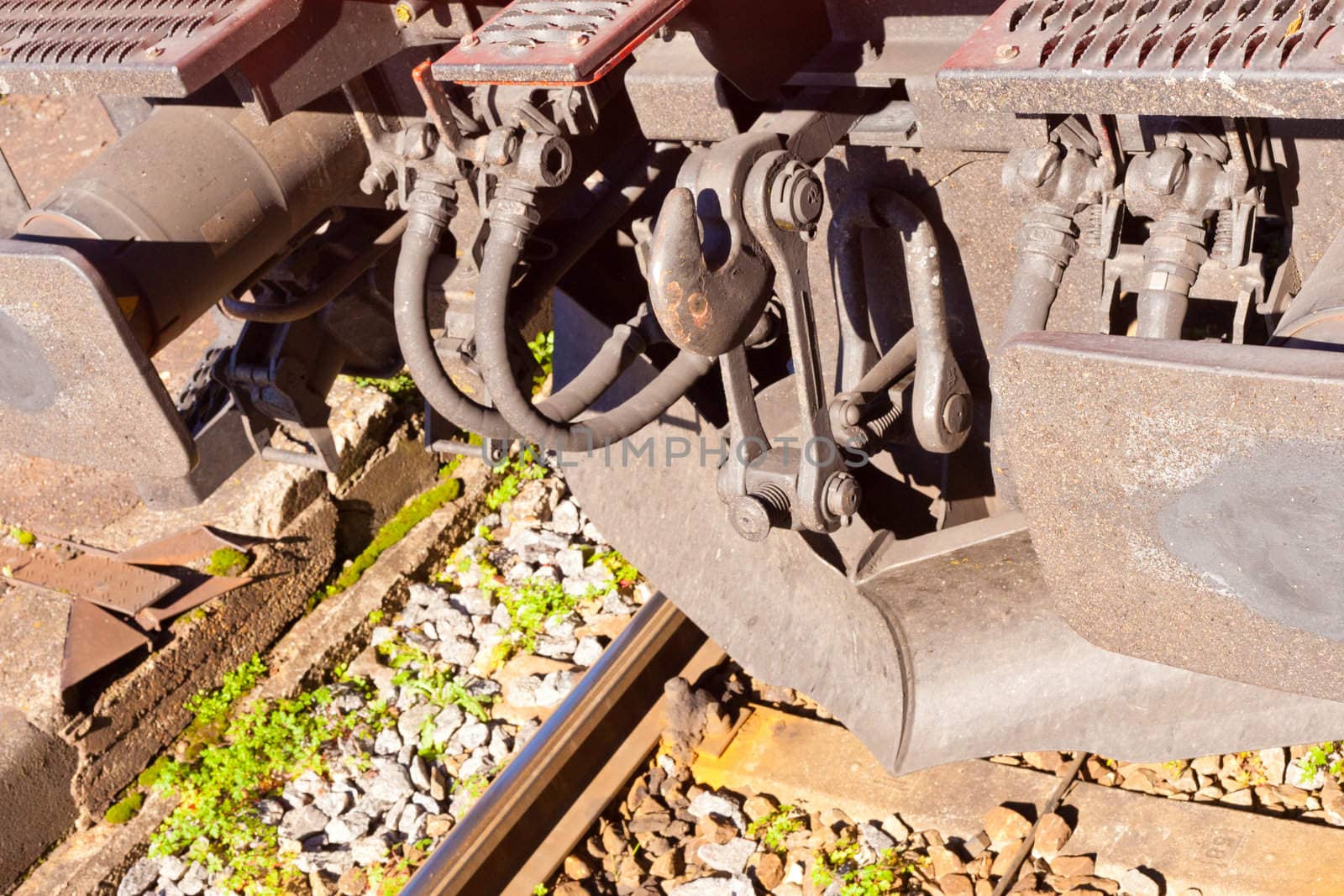 Connector hook, buffers and lower steel frame of locomotive on rail tracks.