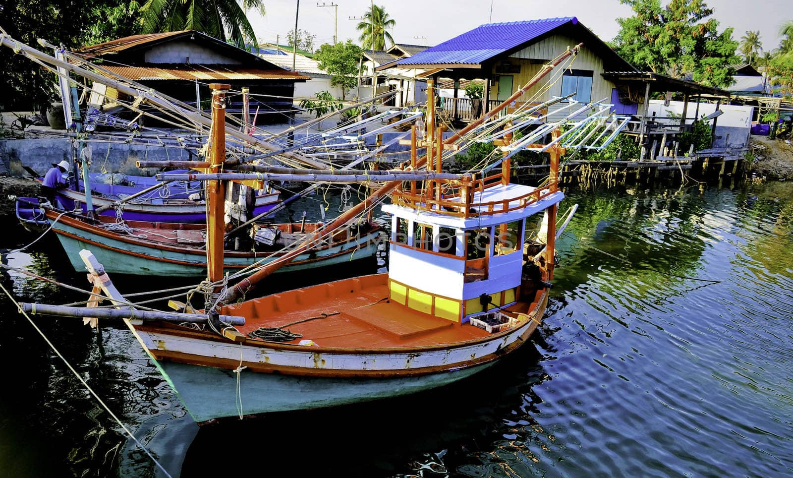 Red and blue fishing boats docked in a bay in Thailand